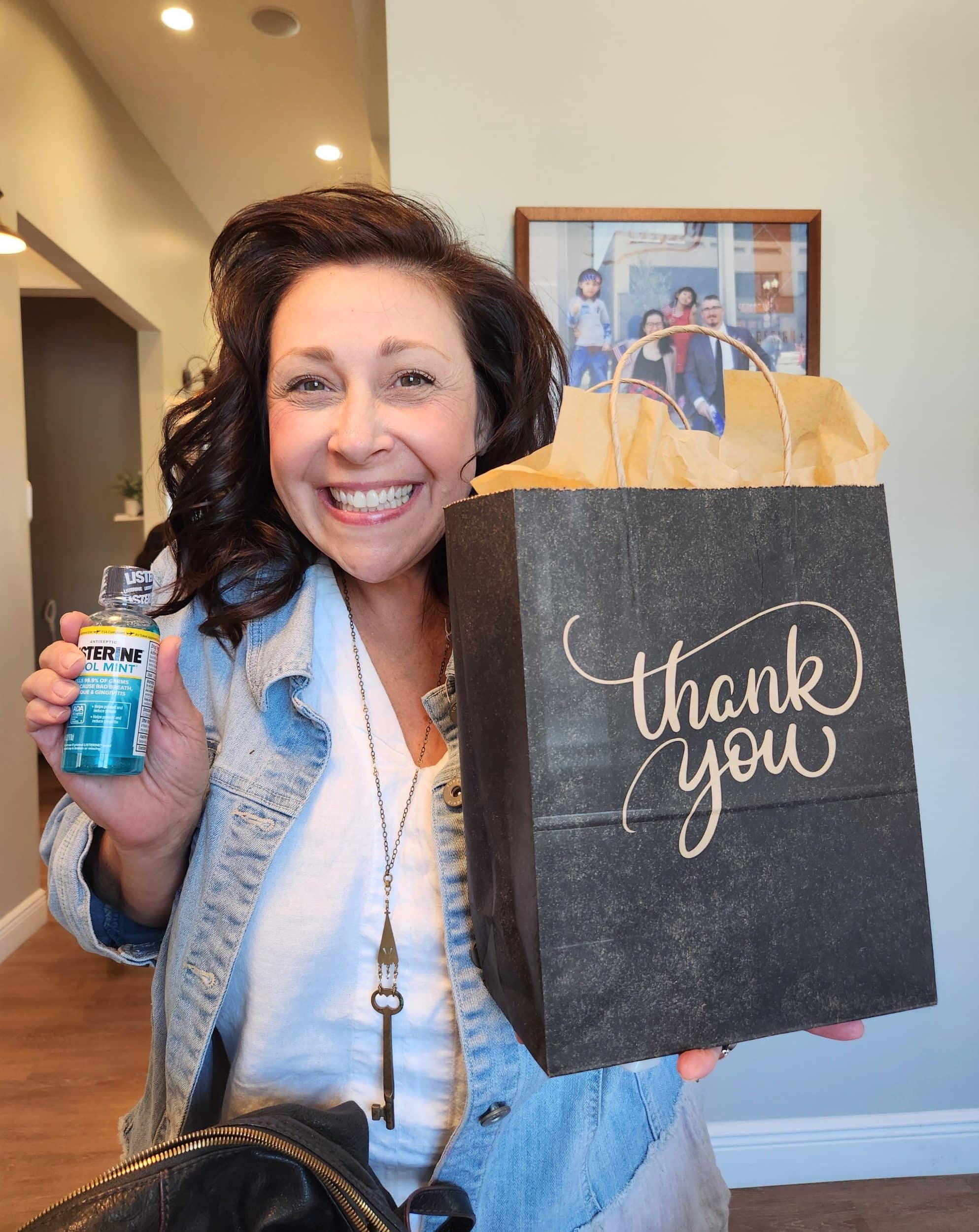 Woman with gift bag and mouthwash smiling